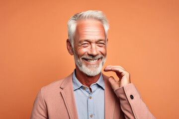 Wall Mural - Close-up portrait photography of a happy mature man making a gesture of i'm thinking with the finger on the head against a pastel orange background. With generative AI technology