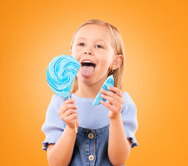 Child, eating lollipop or candy in studio for sweet tooth, color spiral or sugar for energy. Face of happy girl kid on orange background for snack, treat or thinking of dessert or unhealthy food