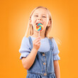 © Mia Bam/peopleimages.com - Lollipop, girl child and portrait of candy in hand, eating and studio for sweets, birthday party or carnival. Sugar, kid and lick spiral snack for dessert, hunger or meal on orange background