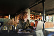 © Flamingo Images - Smiling businesswoman working online with a laptop at a table