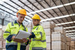 © Supachai - Man and woman workers in uniform with helmet safety holding clipboard discussing and checking wood plank material in pallet factory warehouse.