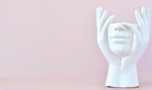 On A Pink Background, A White Plaster Figurine Without A Head