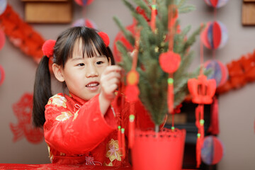 young girl was decorating Chinese New year greeting card against with traditional Chinese 