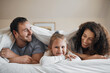 © Wesley/peopleimages.com - Love, happy and child in bed with her parents for bonding, relaxing and resting together with blanket. Smile, excited and portrait of girl kid laying with mother and father in bedroom of family home.