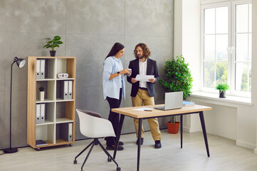 portrait of two confident business people man and woman standing in the office near their workplace 