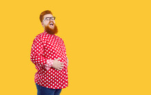 Funny Happy Fat Bearded Young Man Wearing Red White Polka Dot Shirt And Eyeglasses Standing Isolated On Yellow Copy Space Background, Holding His Hands On His Chubby Tummy And Laughing
