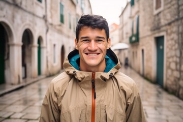 Poster - Headshot portrait photography of a grinning boy in his 30s wearing a lightweight packable anorak at the dubrovnik old town in dubrovnik croatia. With generative AI technology