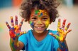 African american little child showing hands with paint,wall with paintings. Street art