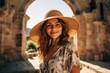 © Markus Schröder - Medium shot portrait photography of a grinning girl in his 20s wearing a whimsical sunhat at the crac des chevaliers in homs governorate syria. With generative AI technology