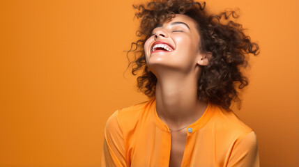 Canvas Print - Young woman laughs against a orange background.