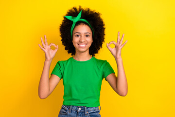 Canvas Print - Portrait of charming cheerful teenager schoolgirl toothy smile arms fingers demonstrate thumb up isolated on yellow color background