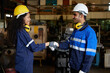 © offsuperphoto - workers or engineers shaking hands for agreement or success at works in the factory