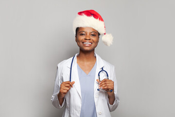 Wall Mural - Smiling young doctor in Santa hat, Christmas portrait