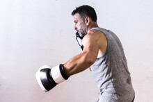 Adult Man Boxer Standing In Boxing Gloves Near White Wall In Daylight