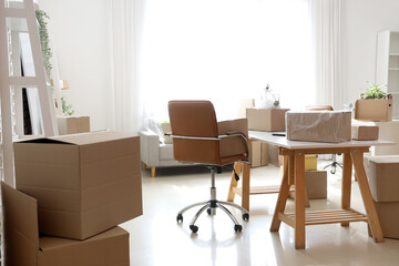 Canvas Print - Modern workplace with cardboard boxes in office on moving day