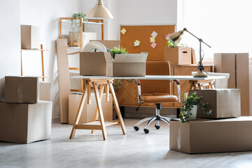 Wall Mural - Modern workplace with cardboard boxes in office on moving day