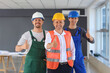 © Pixel-Shot - Team of male builders showing thumbs-up in room