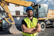 © Antonio Recena - construction worker near to backhoe looking at camera smiling