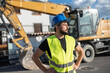 © Antonio Recena - construction worker near to backhoe looking at camera smiling