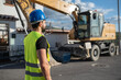© Antonio Recena - construction worker near to backhoe rear view