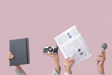 Poster - Female hands with newspaper, notebook, microphone and photo camera on color background