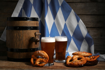 Soft pretzels, glasses with beer and flag of Bavaria on wooden background