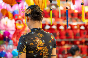 People in front of traditional colorful lanterns hanging on a stand in the streets of Cholon in Ho Chi Minh City, Vietnam during Mid Autumn Festival. Joyful and happy.