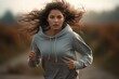 Portrait of a focused young woman running with a blurred background