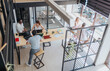© qunica.com - Dynamic business group analyzing statistics, doing paperwork, and strategizing for successful online marketing in a modern office room.