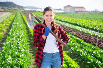 Portrait of a young french woman with hoe working in a farm on warm sunny day