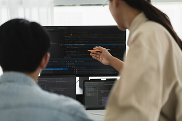 Wall Mural - two developer programmer discussing to checking code on monitor about programming to developing web