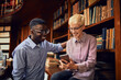 © Marko Geber - Two young students talking and using a smart phone while studying together in a university library