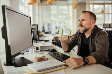 Middle aged caucasian man using a computer at a office job