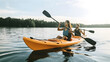 © May - Man and woman couple riding kayak in lake at sunset
