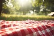 © Fokasu Art - Red and white plaid picnic blanket on top of a green field in sunny day on grass of lawn in summer park. Blurred Background. Generative AI