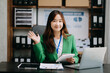 © Nuttapong punna - Confident business expert attractive smiling young woman holding digital tablet  on desk in creative office..