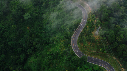 Aerial view road in the middle forest, Top view road going through green forest adventure, Ecosystem ecology healthy environment road trip travel net zero