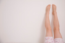 One pair of legs up a white wall
