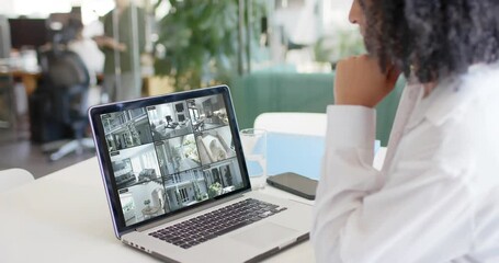 Poster - Biracial female security officer watching home cctv camera views on laptop, slow motion