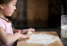 Young Girl Rolling Dough On Table
