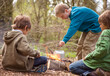 © fStop - Three boys around campfire boiling water in a kettle
