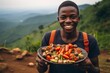 happy african boy holds in his hands a tray with vegetables