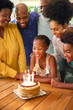 © Monkey Business - Multi-Generation Family Celebrating Granddaughter's Birthday With Cake And Candles At Home