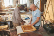 © Seventyfour - Portrait of two carpenters working together building wooden furniture in workshop, copy space