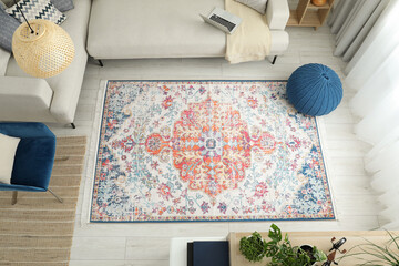 Poster - Stylish living room with beautiful carpet, comfortable sofa and pouf, above view. Interior design