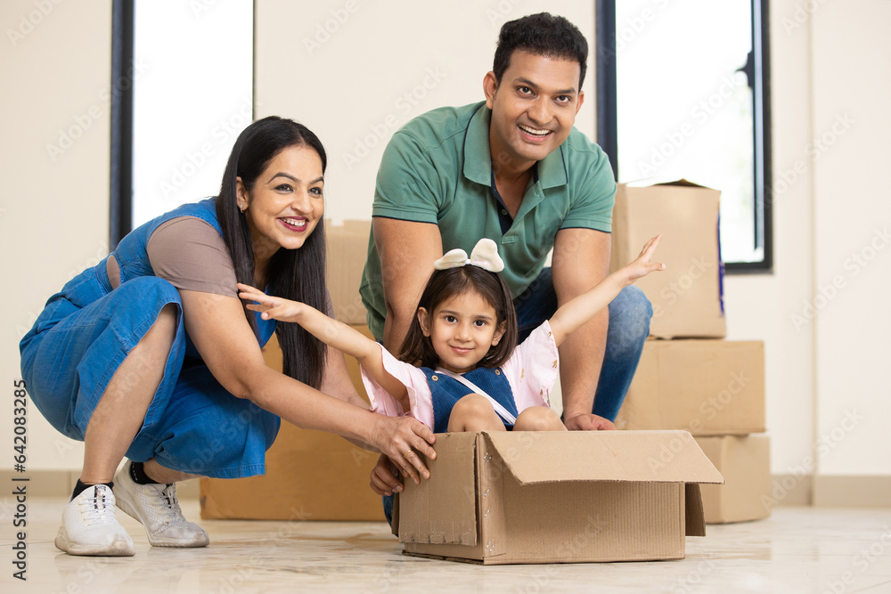 Happy young indian family with kid having fun in new home. Playing with ...
