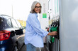 © Ivan Traimak - Mature adult woman uses the gas station on her own