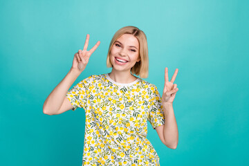 Photo of cheerful optimistic woman with bob hairstyle dressed stylish t-shirt showing v-sign symbol isolated on teal color background