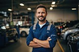 Technician male auto mechanic crossed arms in modern auto repair shop, garage.