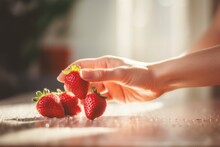 Woman Hand Grabing Fresh Red Strawberries From The Kitchen Table
